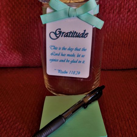 blue-themed glass jar with ribbon, laminated quote tag, paper pad, and pen